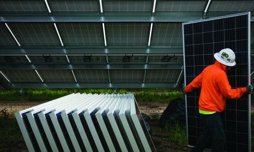 一名工人拿着一块太阳能电池板