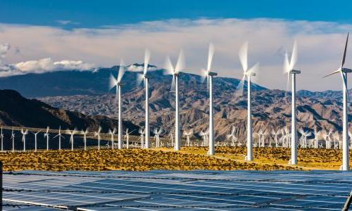 Wind turbines behind a solar farm